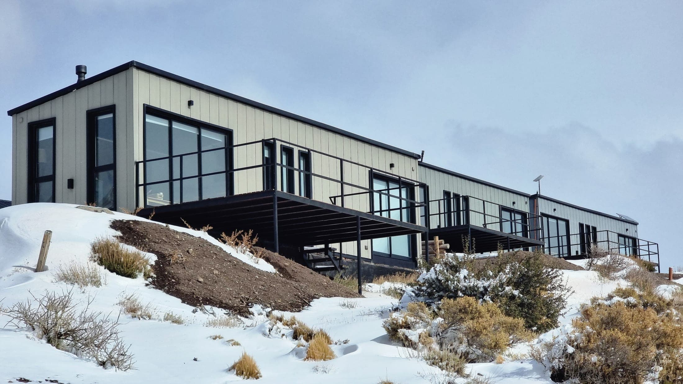 Cabañas de Summit Trip Winter Lodge sobre la nieve, con la cordillera de fondo