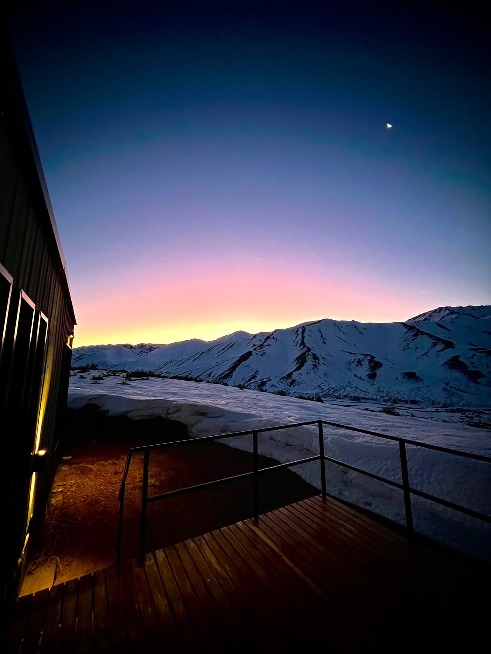 Las cabañas al anochecer con la cordillera nevada de fondo