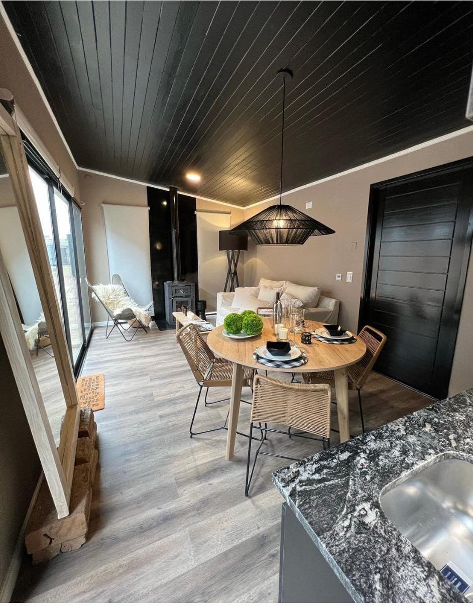 Living comedor de la Cabaña 2 con estufa a leña y mesa puesta